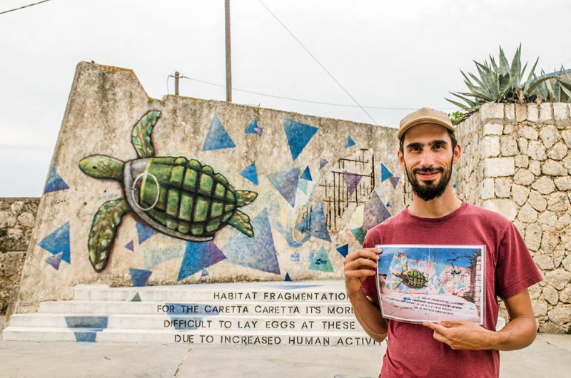Holding the sketch infront of the mural